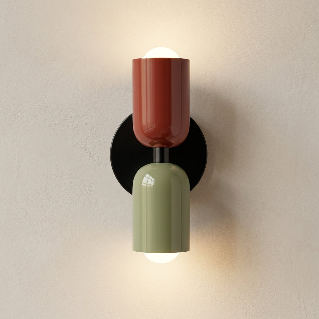 Decorative wall sconce with two cylindrical shades, one red and one green, on a white background.