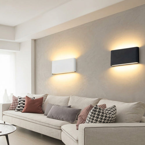 Modern living room with a white sofa and decorative pillows, featuring wall lights.