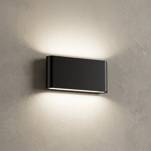 A modern rectangular black wall-mounted light fixture with a horizontal LED strip, shown illuminated against a white wall.