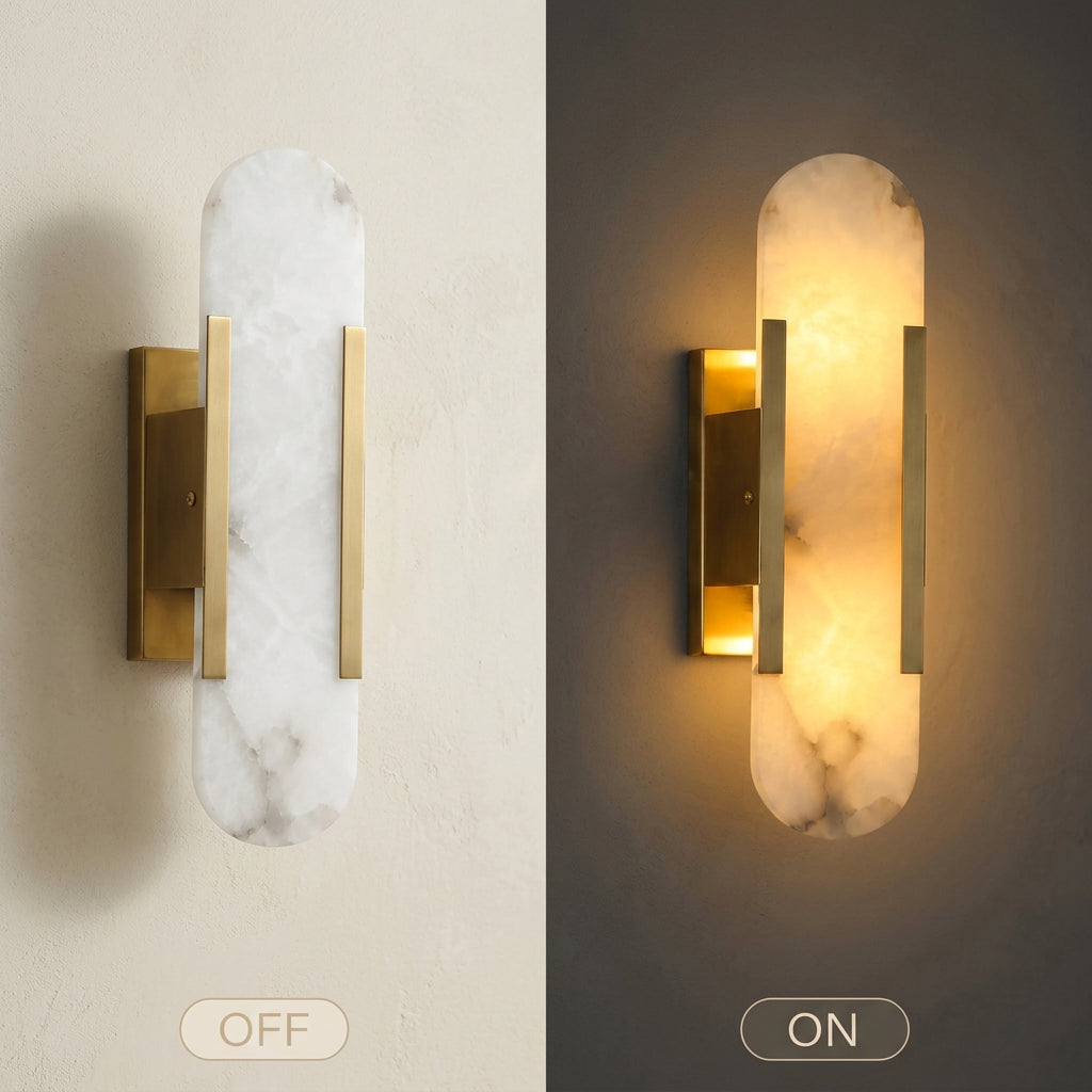 A wall-mounted light fixture shown in two side-by-side views: off to the left on a white wall, and on to the right glowing warm yellow against a dark wall. The fixture has a vertical white marble-look panel with subtle gray veining and brushed gold metal side bars and mounting bracket.